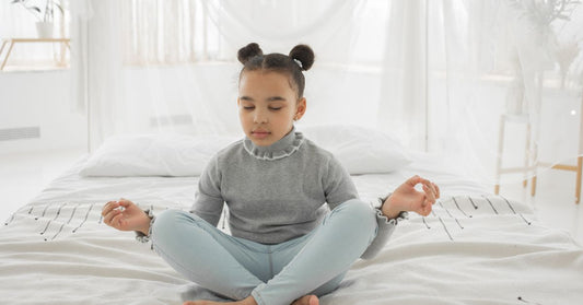 Kid sitting on top of bed