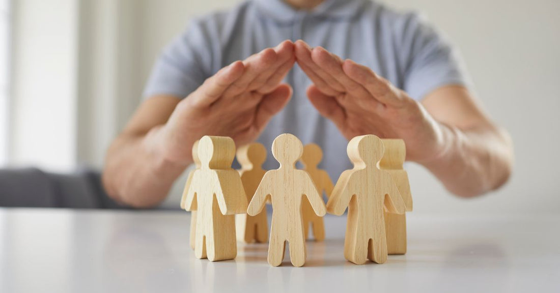 Person holding hands over little pawn people