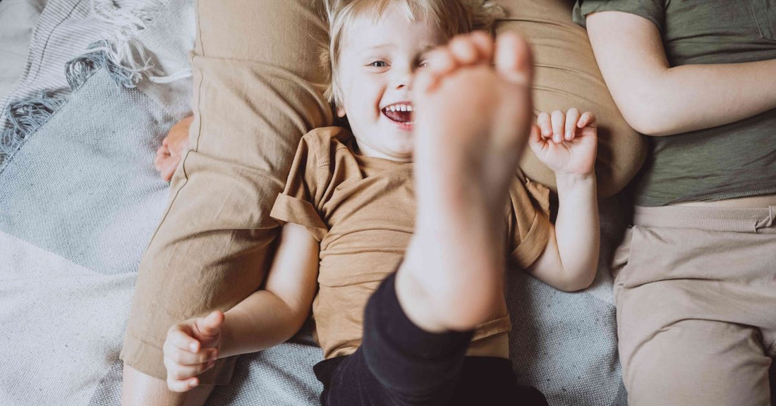 Toddler Playing in Bed with His Family